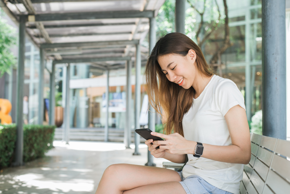 Portrait of Attractive Happy Asian Woman Holding Smartphone