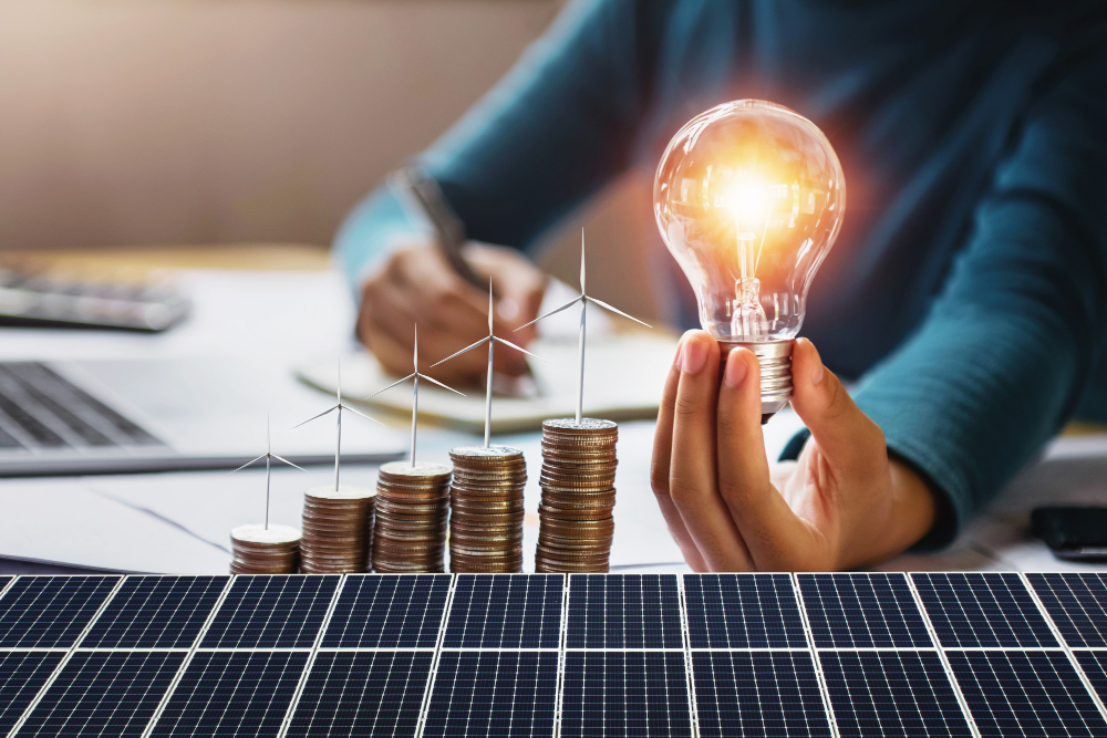 Hand Holding Light Bulb With Solar Panel Background