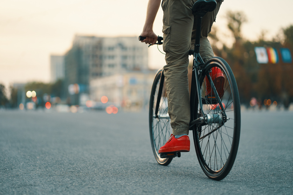 Closeup of casual man legs riding classic bike on city road 