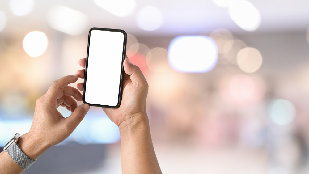 Mobile Smart Phone in Man’s Hand at Desk Work