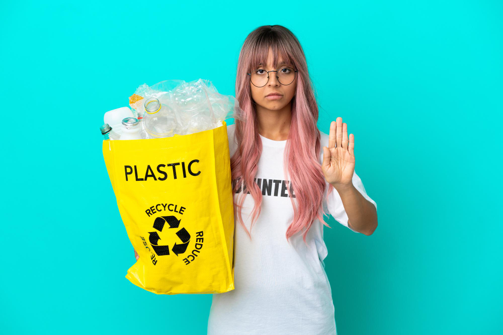 Young Woman With Pink Hair Holding a Bag Full of Plastic Bottles To Recycle