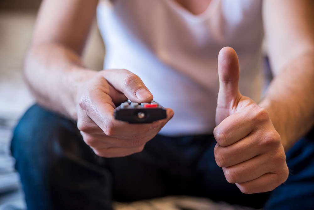 Man Holding a TV Cable Remote Control