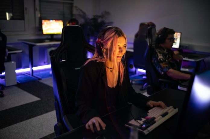 A woman sitting in front of a computer monitor video games, npc ai, immersive experiences