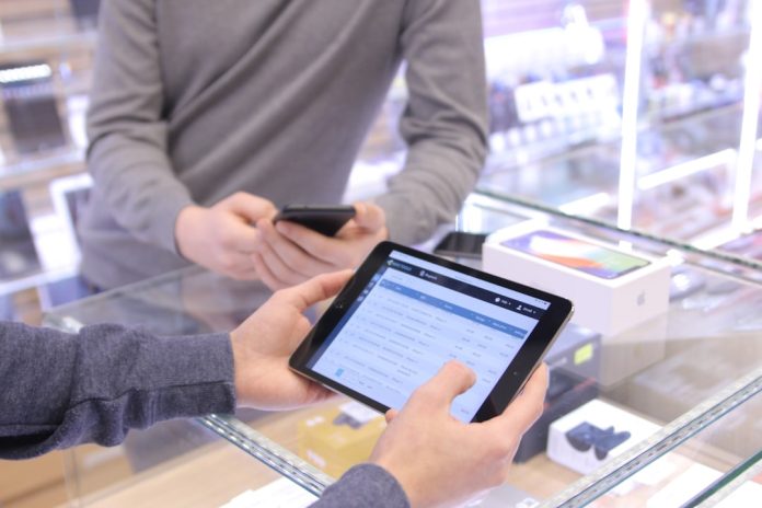 two people are looking at a tablet in a store international checkout form ecommerce customer experience