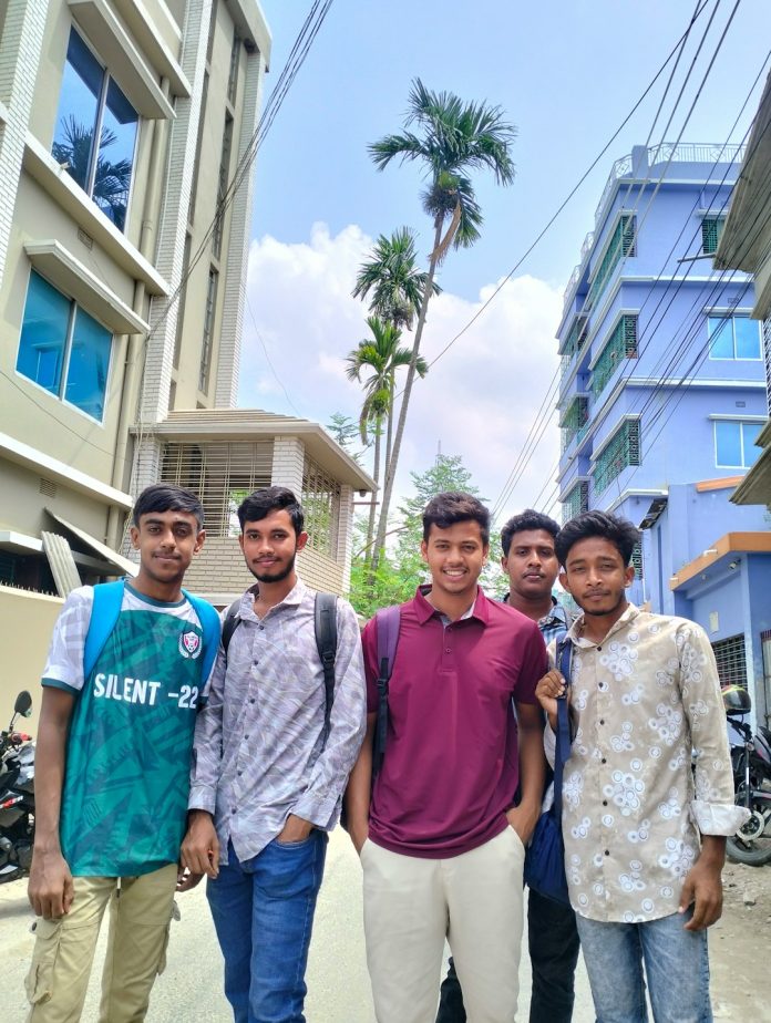 Five young men standing outdoors with buildings and trees. students mac netbeans educational java