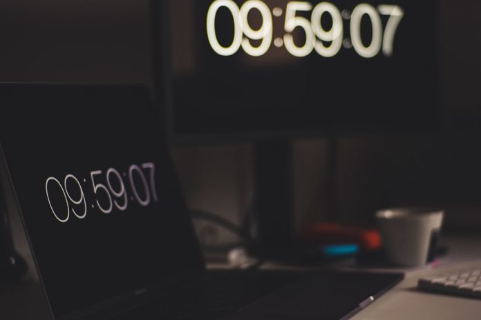 black laptop computer showing 9:59:07 laptop screen domain search website modern workspace
