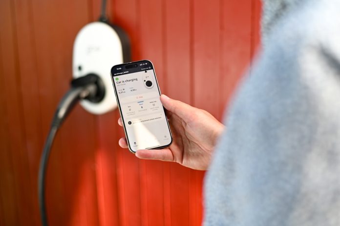 Person uses phone to control electric vehicle charger. google pay app interface smartphone tap