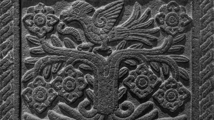 a close up of a carving on the side of a building ancient texts, folklore, mystical symbols