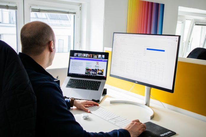 a man sitting at a desk using a computer seo analytics dashboard, website traffic charts, laptop analytics screen, digital marketing metrics