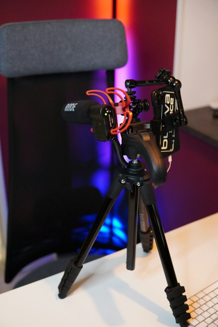 black camera with tripod on black table streaming gear, gaming camera, gamer microphone