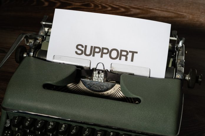 a close up of a typewriter with a paper on it technical support team, customer service headset, website troubleshooting session