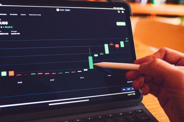 a person is holding a pencil in front of a laptop laptop screen showing sales analytics dashboard charts graphs