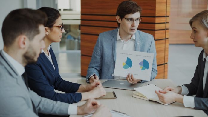 Team discussing charts during a business meeting. enterprise financial reporting dashboard, compliance documents, accounting team meeting