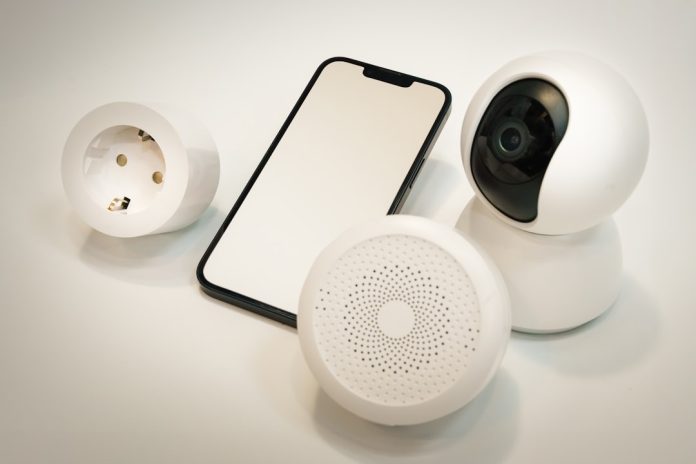A cell phone and a camera sitting on a table smart home ecosystem diagram, connected devices network, security sensors, home automation interface