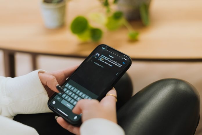 a person sitting on a couch holding a cell phone person using voice assistant, smart speaker query, ai chatbot interface