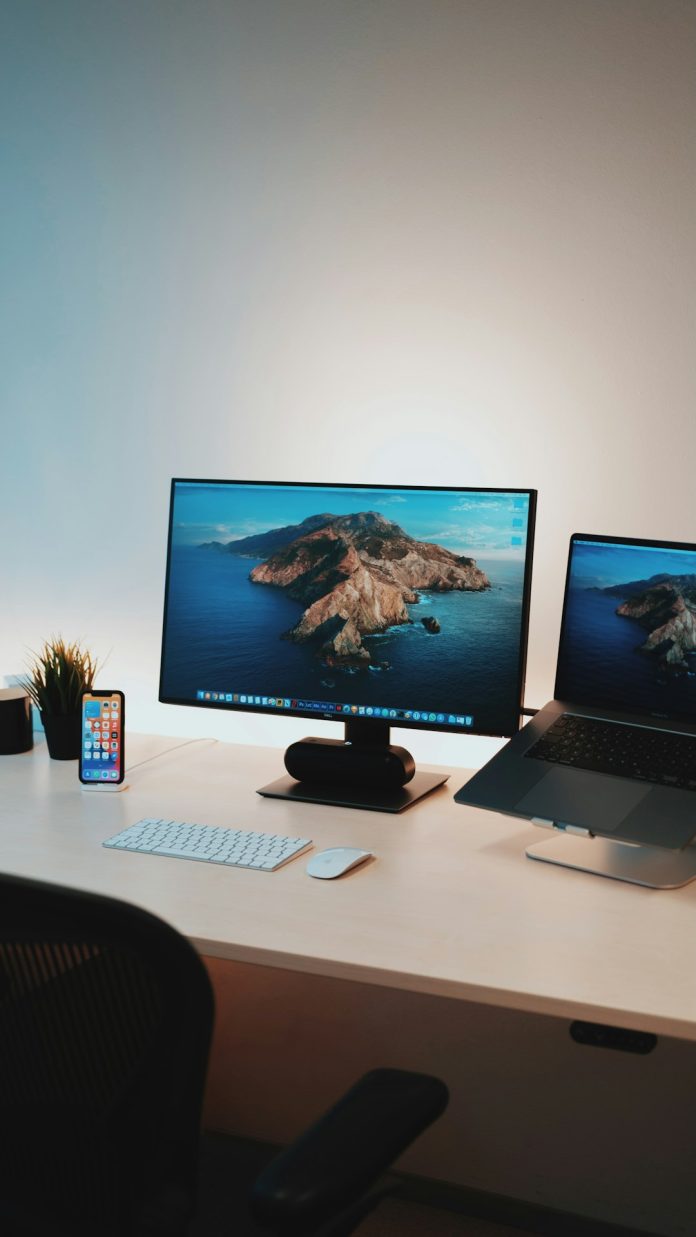black flat screen computer monitor on white table ipad and iphone on table, apple devices screen, find my location setup