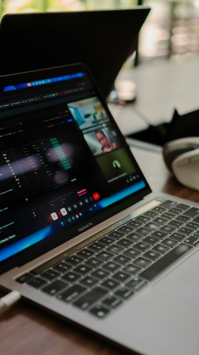 Laptop screen shows a video conference with multiple participants. remote team video call global connectivity