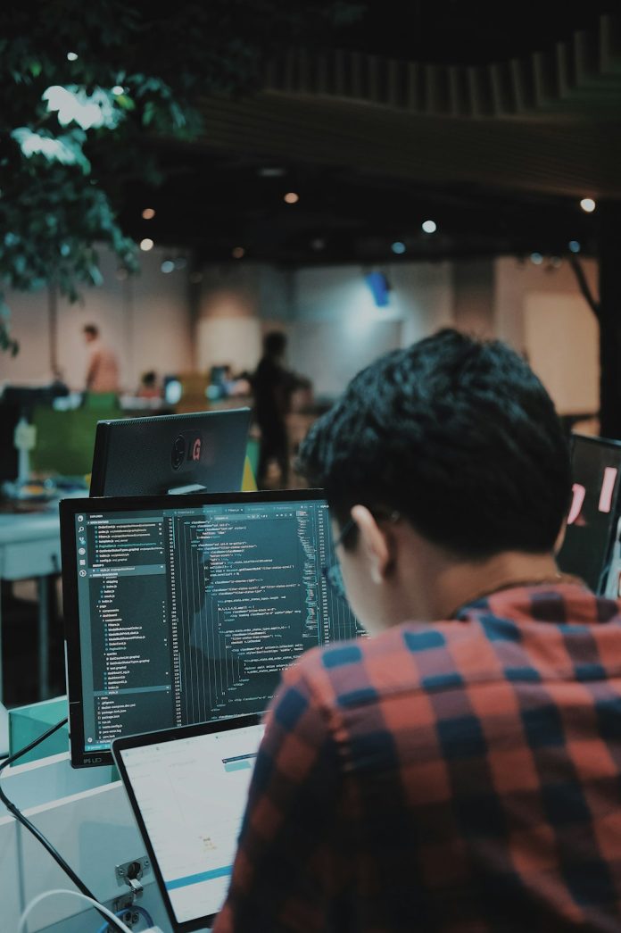 sitting man using gadget in room developer coding mobile app payment integration workstation