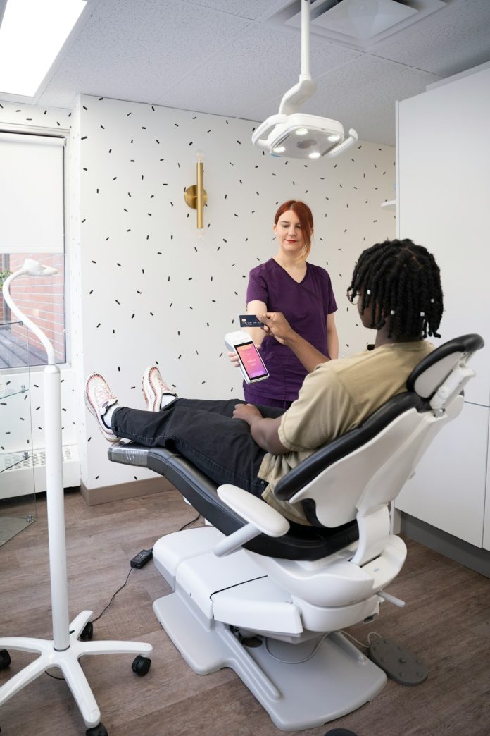 a woman sitting in a chair with a tablet smiling dental team, patient consultation, modern clinic