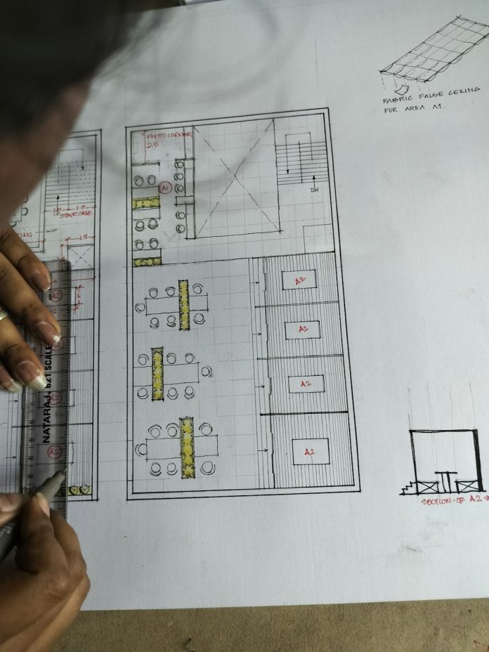 a person is drawing a floor plan on a piece of paper dimension lines, floor plan, measurement check