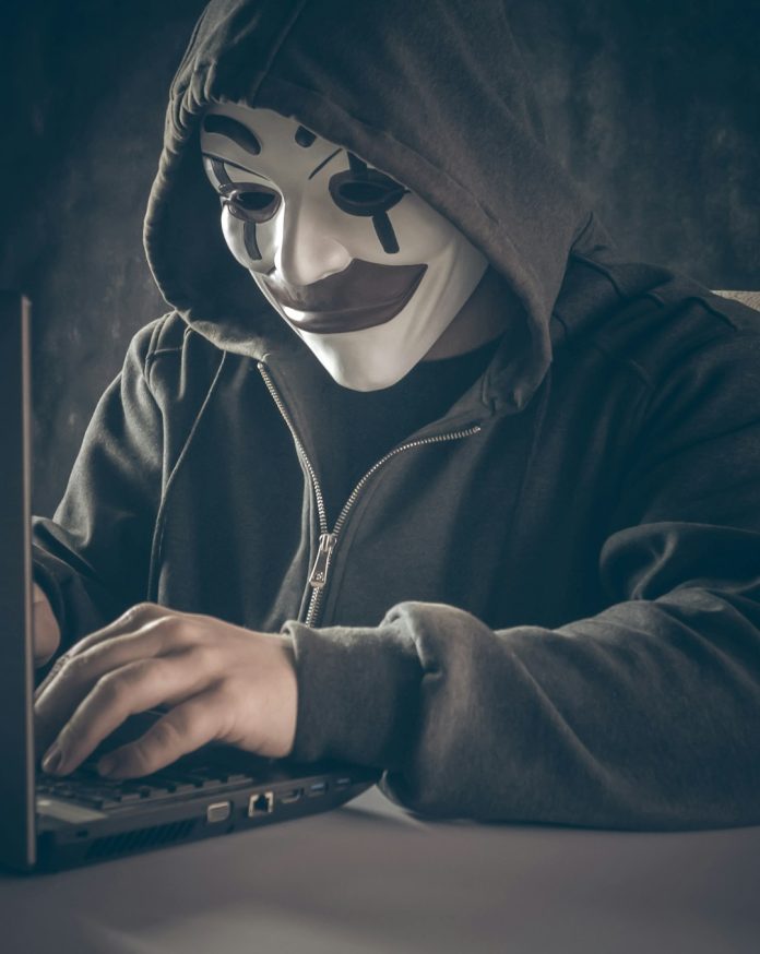 a person wearing a mask using a laptop cybersecurity checklist, anonymous browsing, safe setup