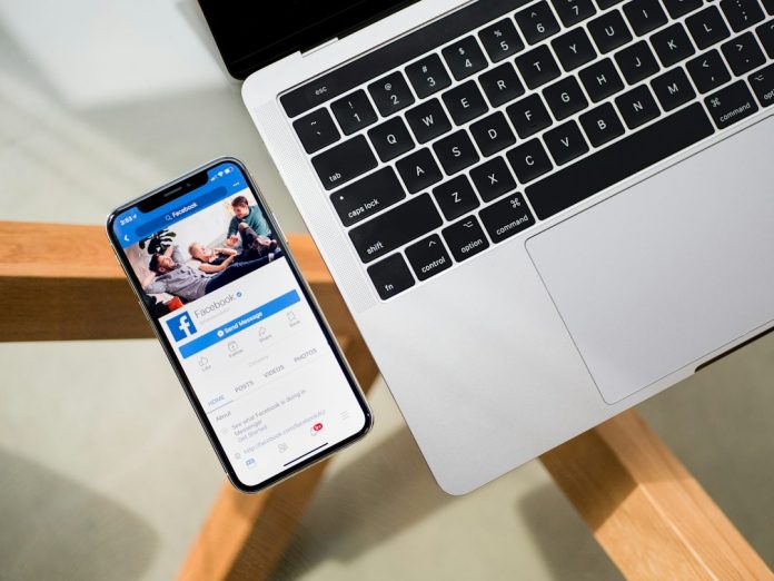 iPhone X beside MacBook facebook ad library search, competitor ads, social media research