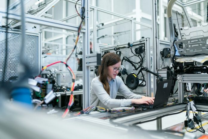 woman in white long sleeve shirt using black laptop computer factory sales team, industrial buyer, laptop leads